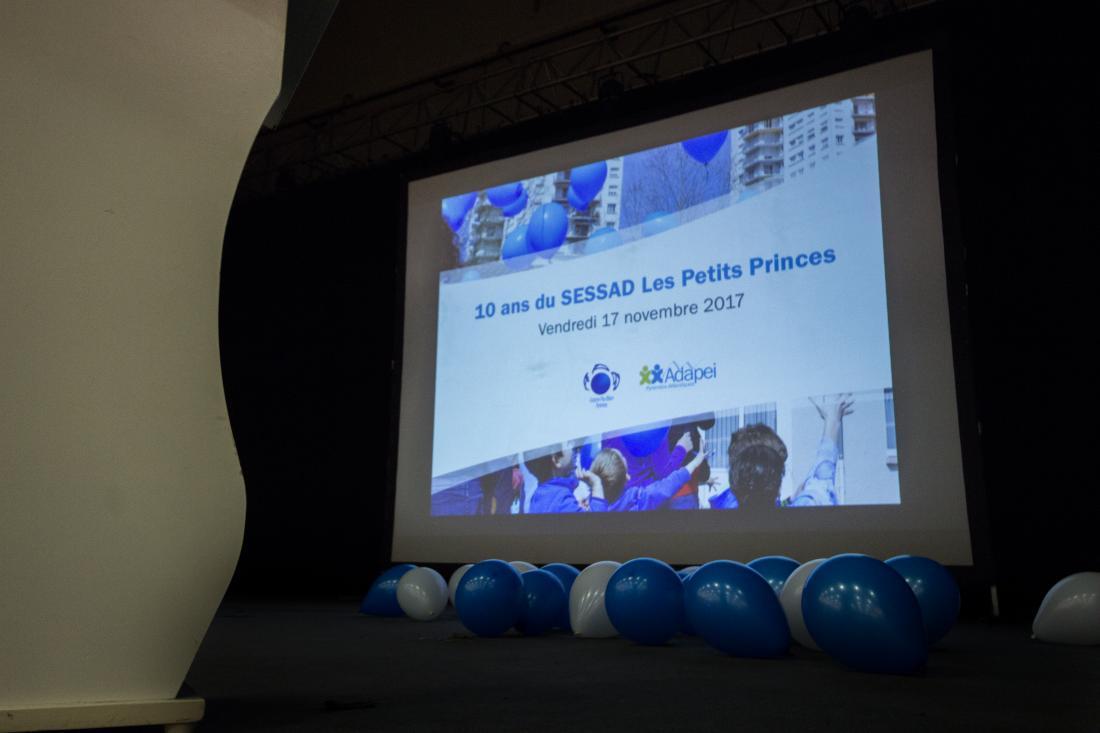 La scène de l'Espace Balavoine remplie de ballons blancs et bleu pour fêter les 10 ans du SESSAD Les Petits Princes